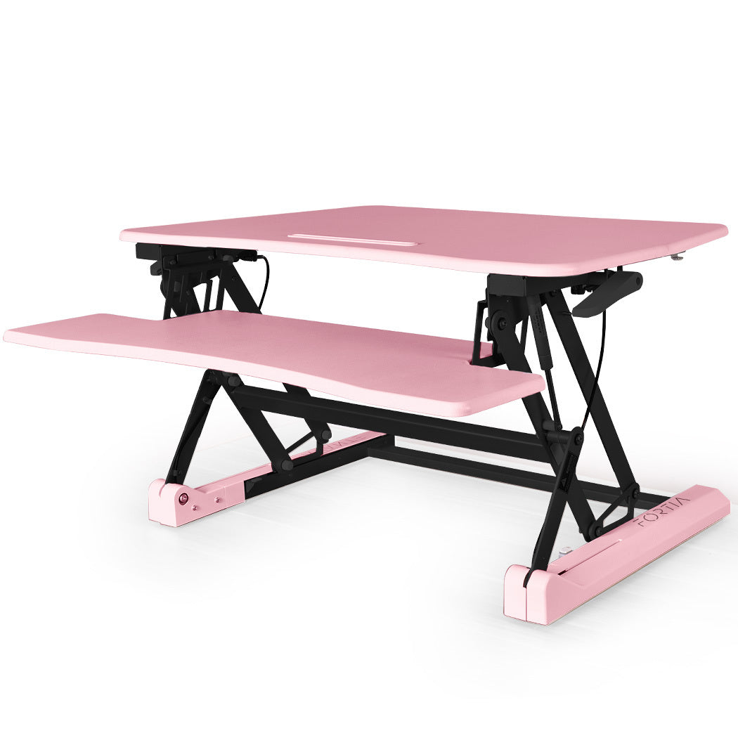 Image of fortia desk riser 90cm wide adjustable sit to stand for dual monitor, keyboard, laptop, pink suitable for aged care, corporate offices, and commercial settings